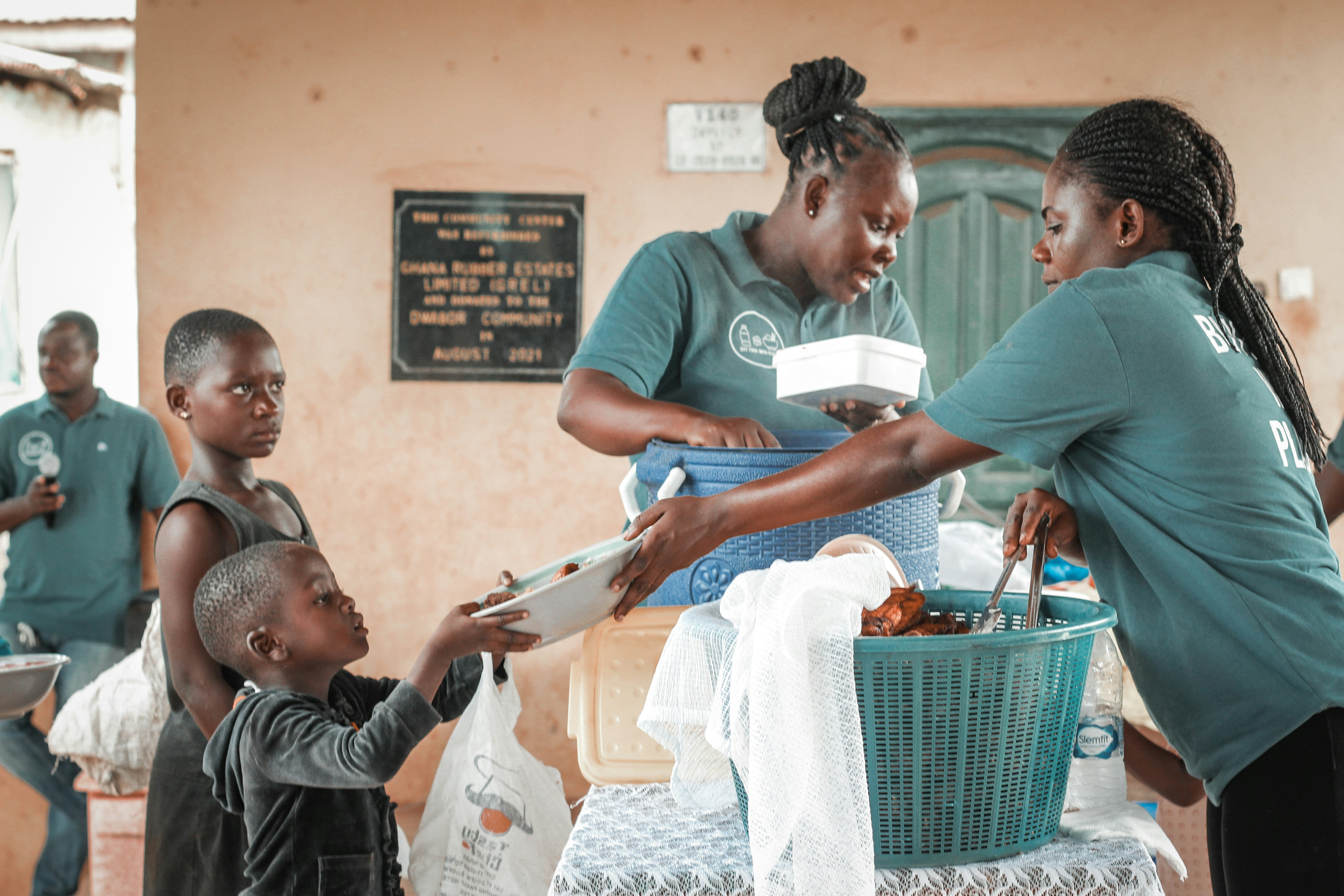 Volunteers handing food parcels to families at sunset